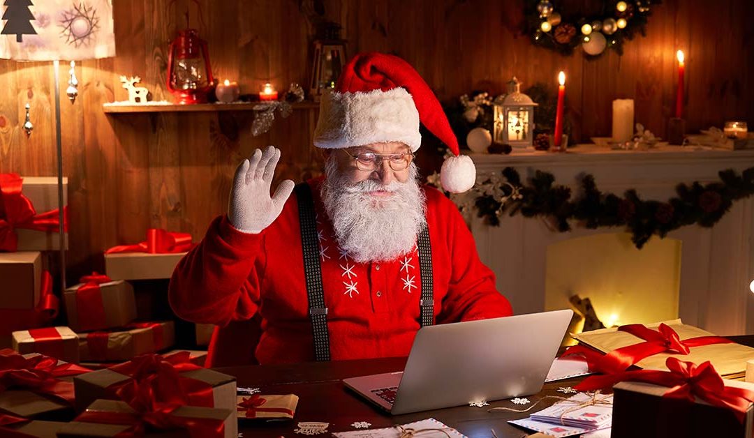 Weihnachtsman in seinem Haus vor dem Laptop